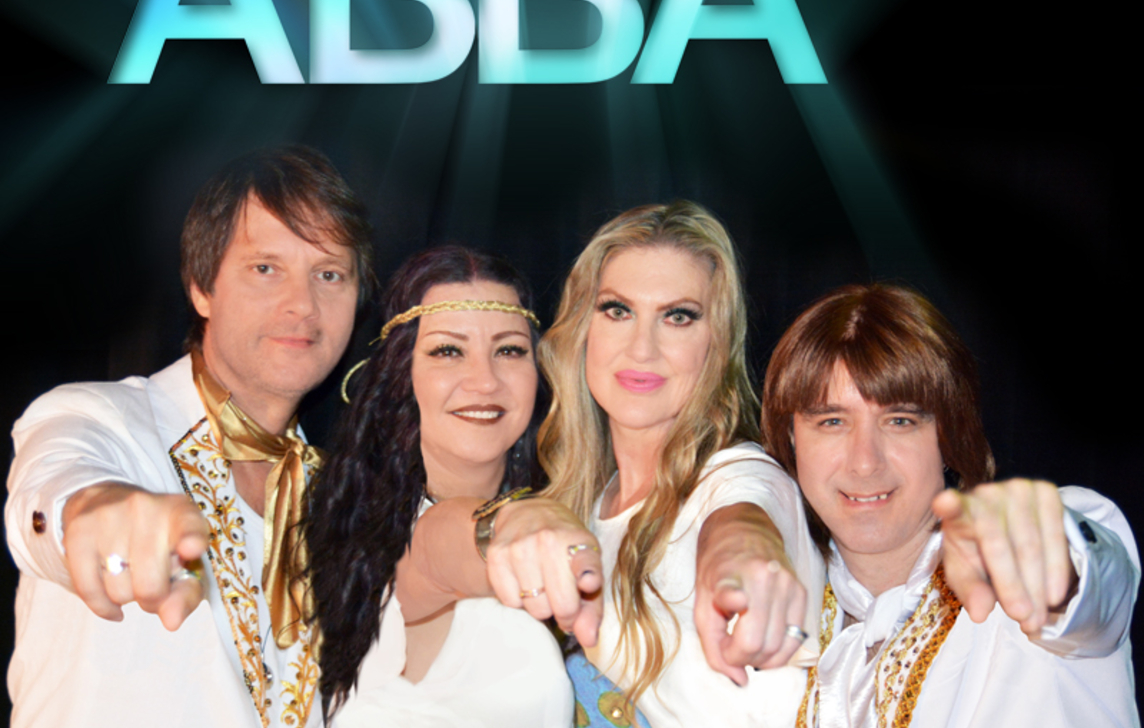 Dressed in all-white, the members of ABBA LA point directly at the camera.