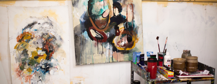 two paintings with art supplies on a cart