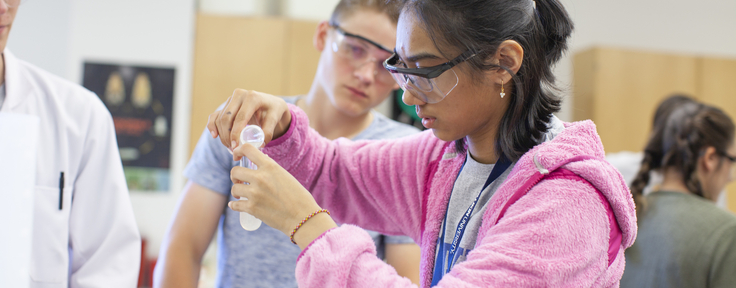 student measuring pouring fluid from a test tube