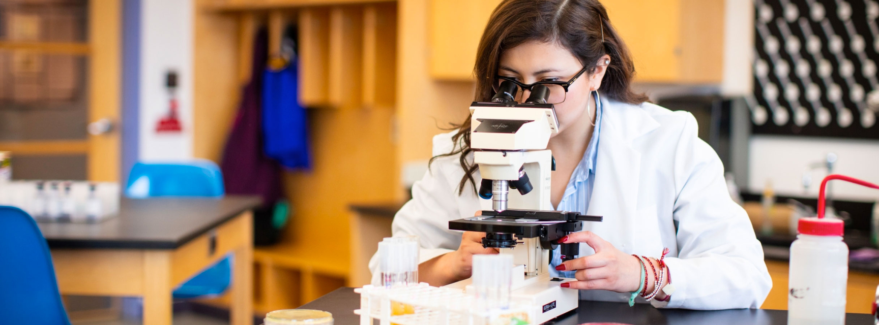 student using microscope