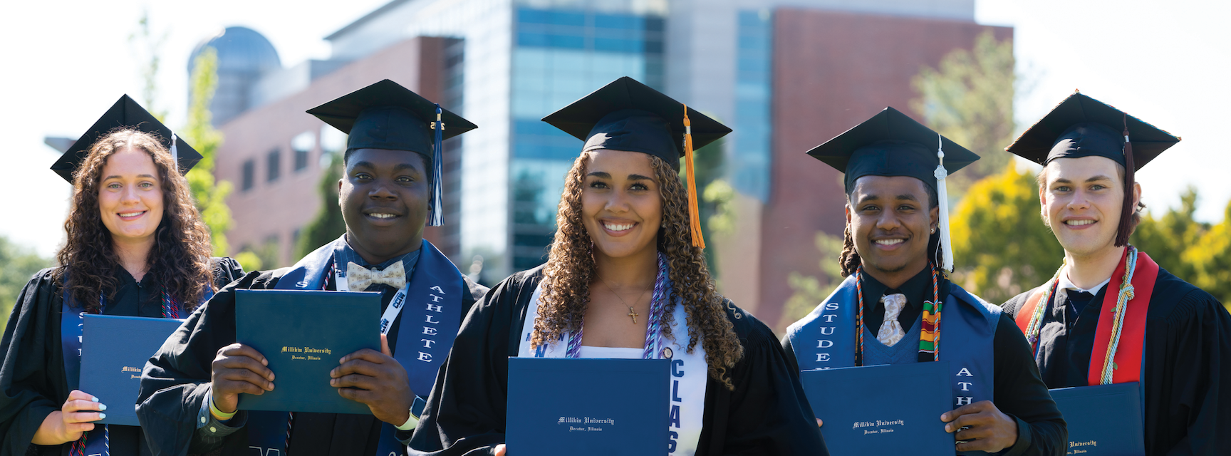 5 graduating students smiling