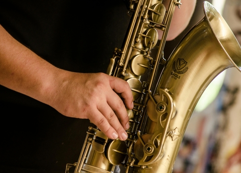 A man&#039;s hand plays the saxophone.