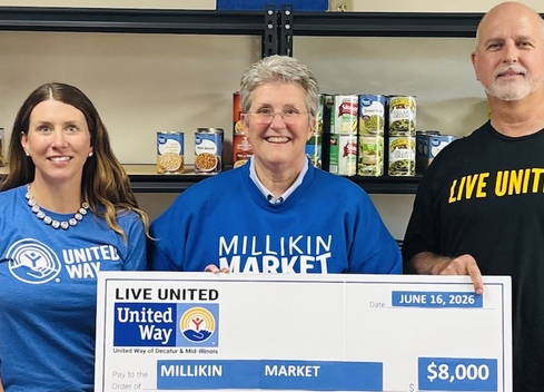 3 people presenting check for millikin market