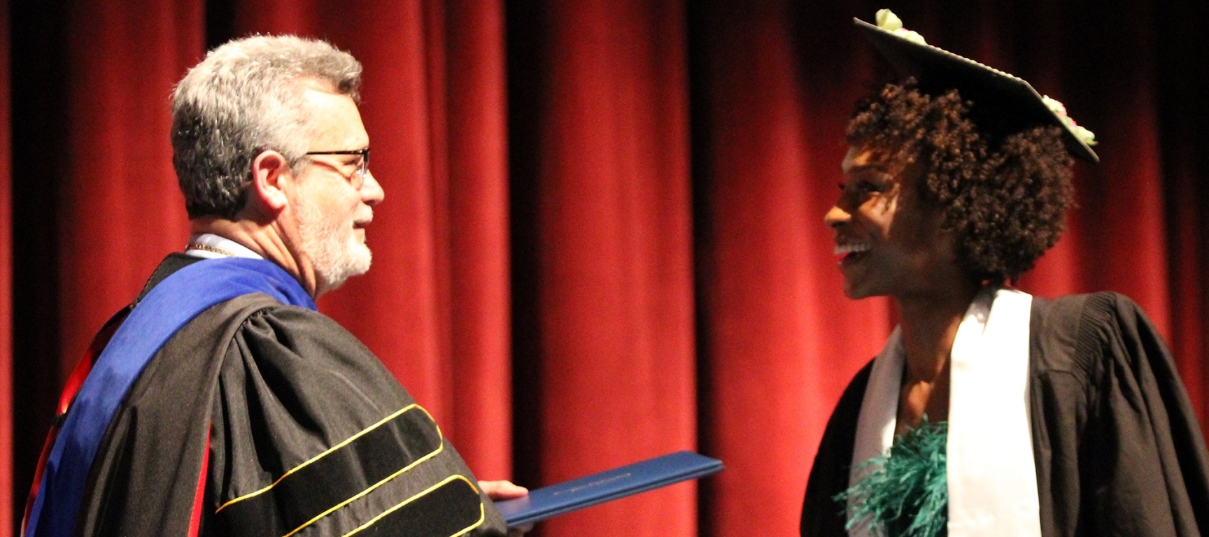 President Jim Reynolds presenting student with diploma