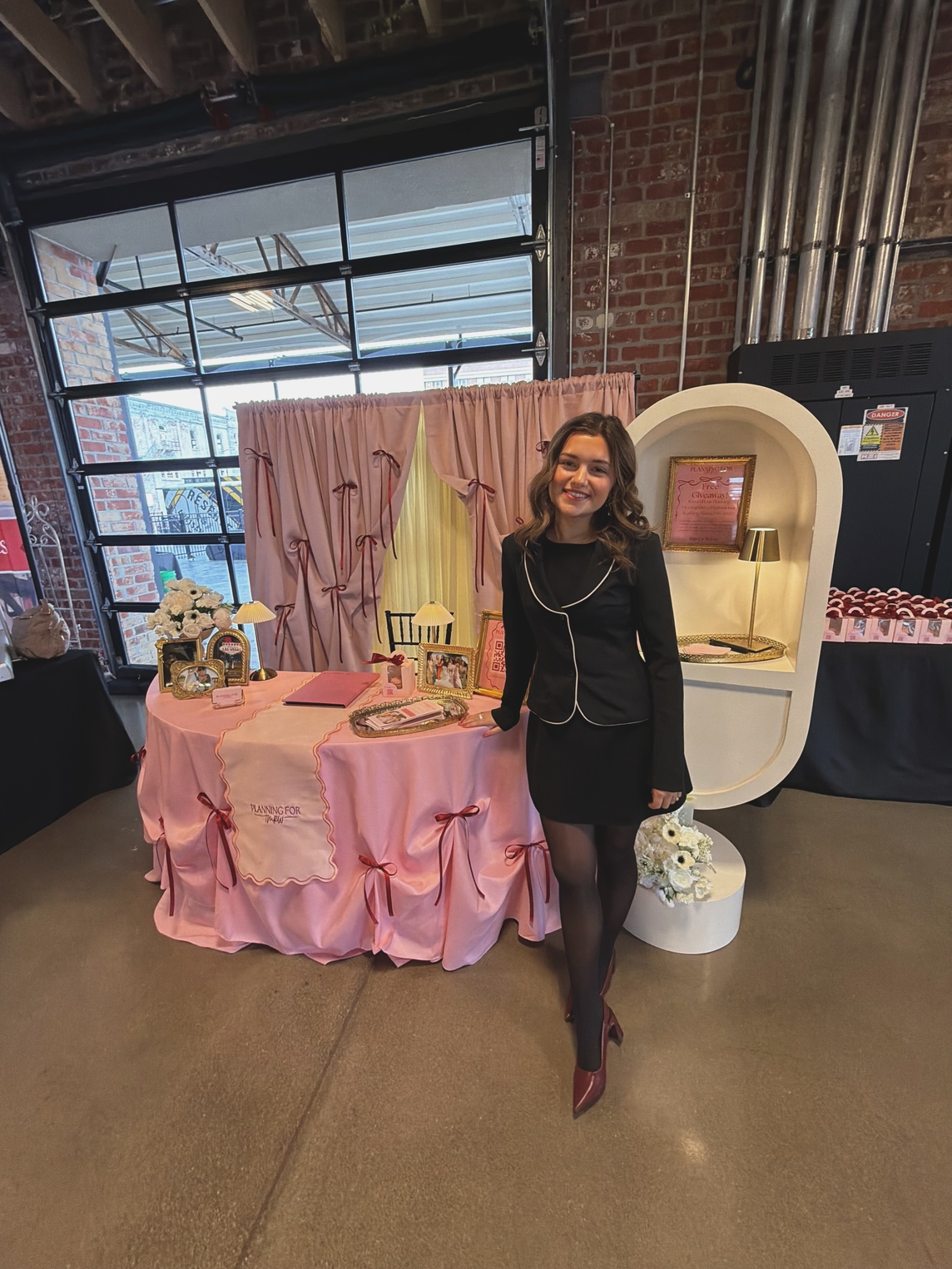 MaryHelen Maida poses at a booth promoting her wedding planning business