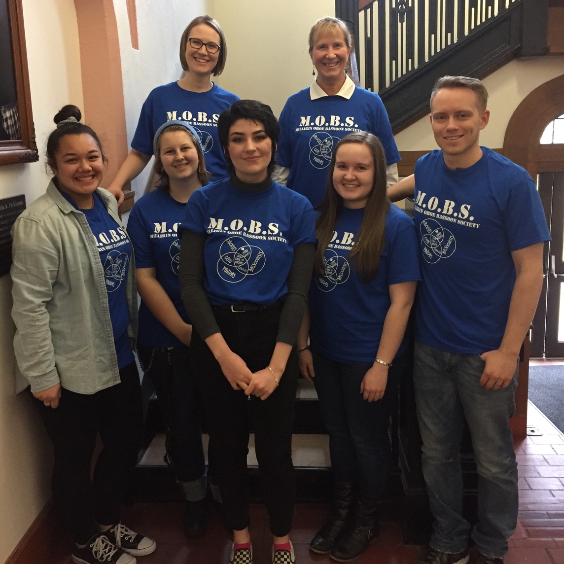 group of people on stairs in matching shirts