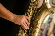A man&#039;s hand plays the saxophone.
